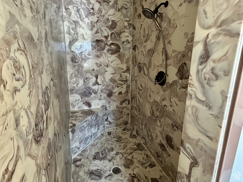 Full bath with a tile shower and a textured ceiling