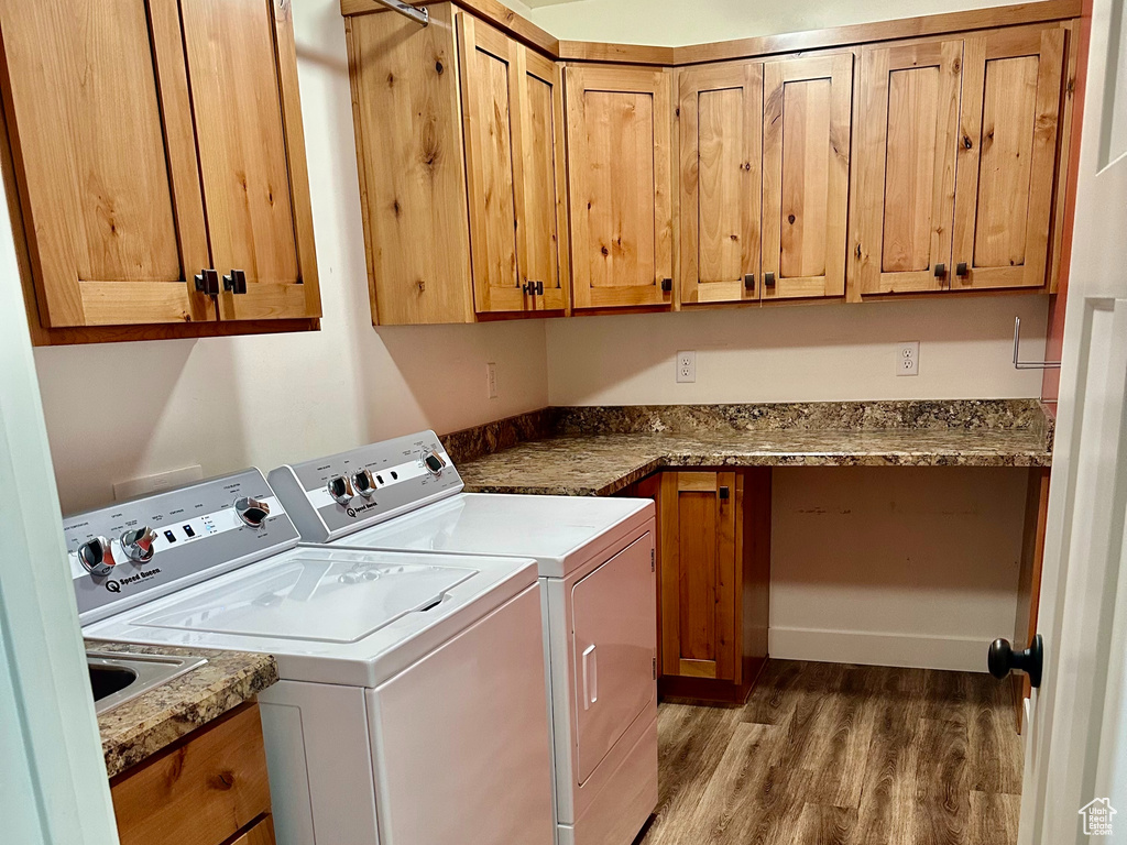 Laundry area featuring washer and dryer, wood finished floors, cabinet space, and a textured ceiling