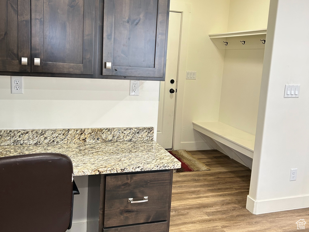 Home office featuring baseboards, built in study area, a textured ceiling, and light wood-style floors