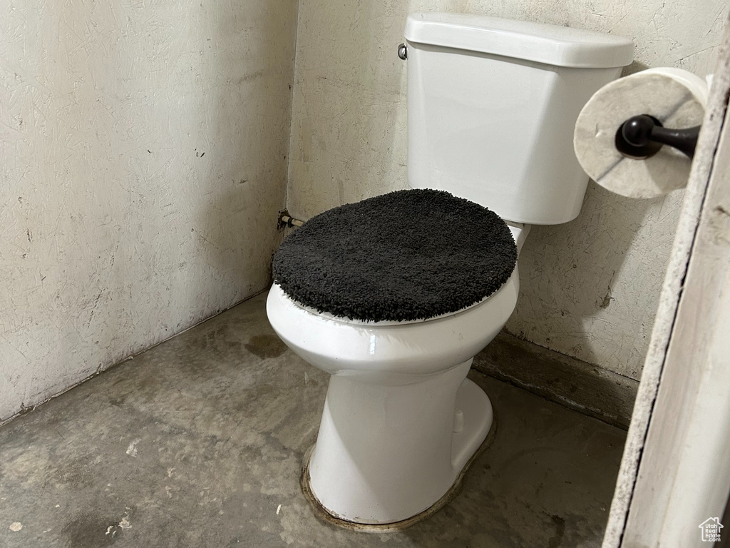 Bathroom featuring toilet and concrete flooring