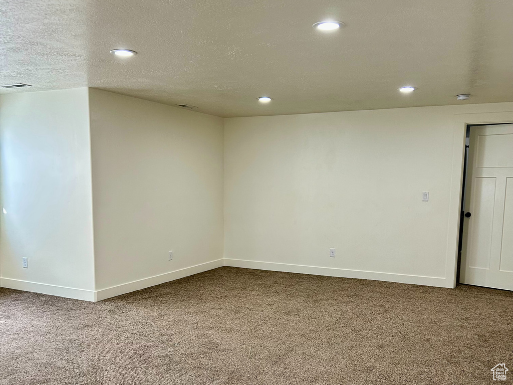 Empty room featuring carpet flooring, recessed lighting, a textured ceiling, and baseboards