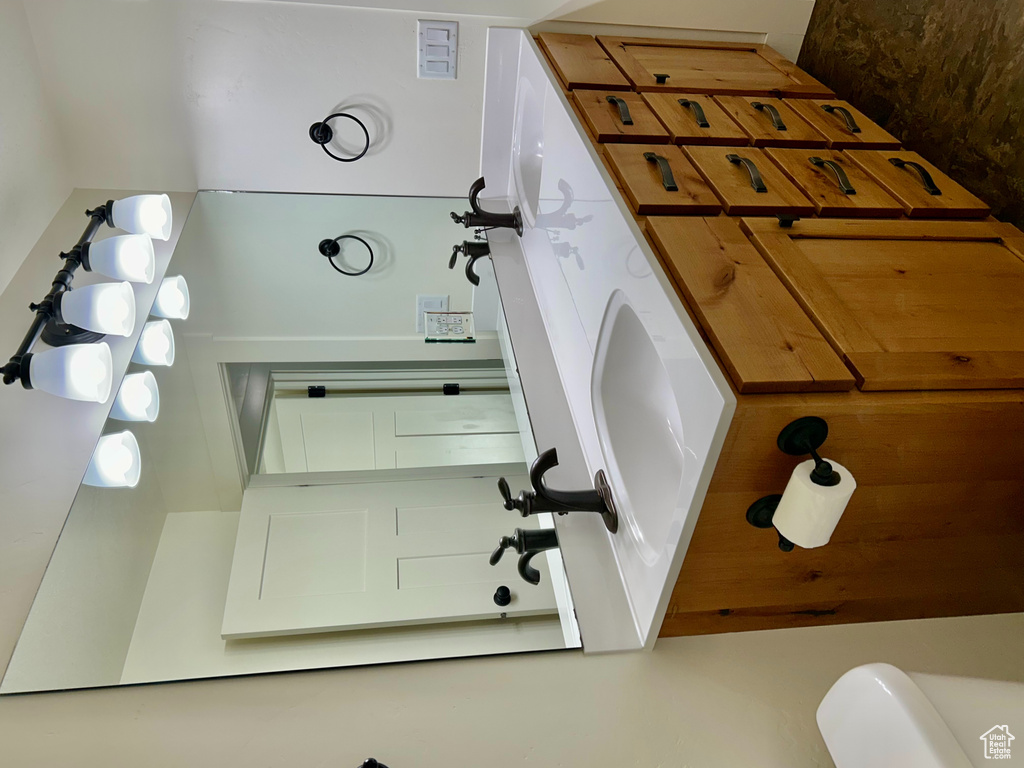 Bathroom featuring double vanity, toilet, and a sink