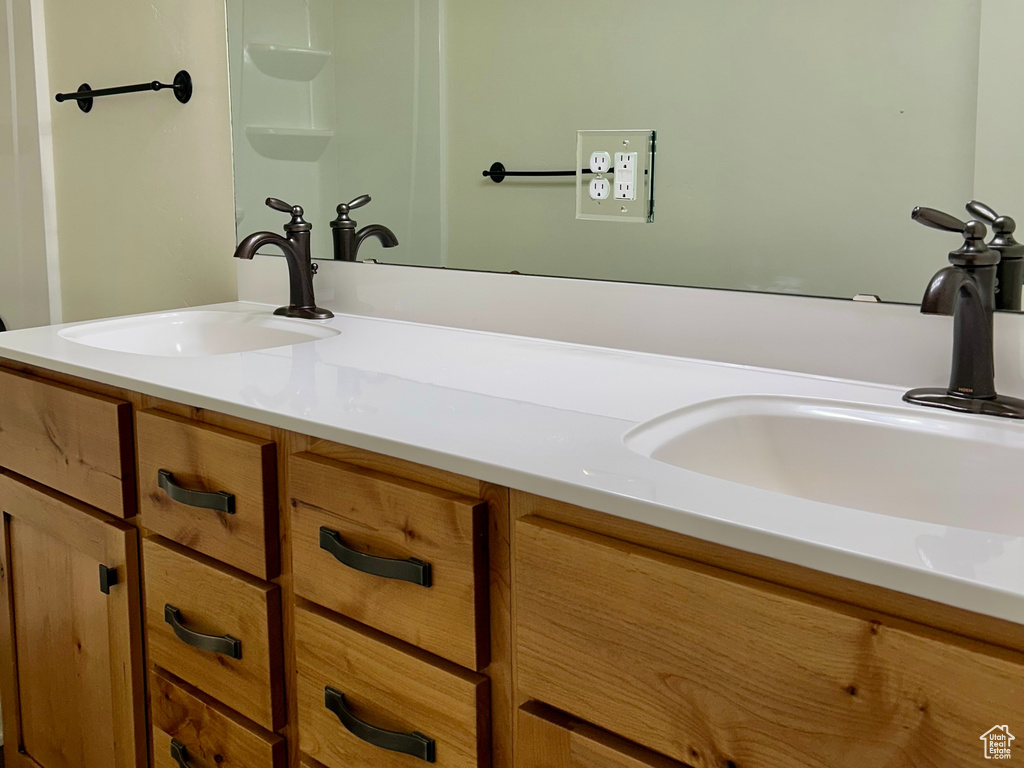 Full bathroom with double vanity, a shower, and a sink