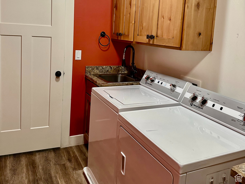 Laundry area with dark wood-style floors, cabinet space, a sink, a textured ceiling, and washer and dryer