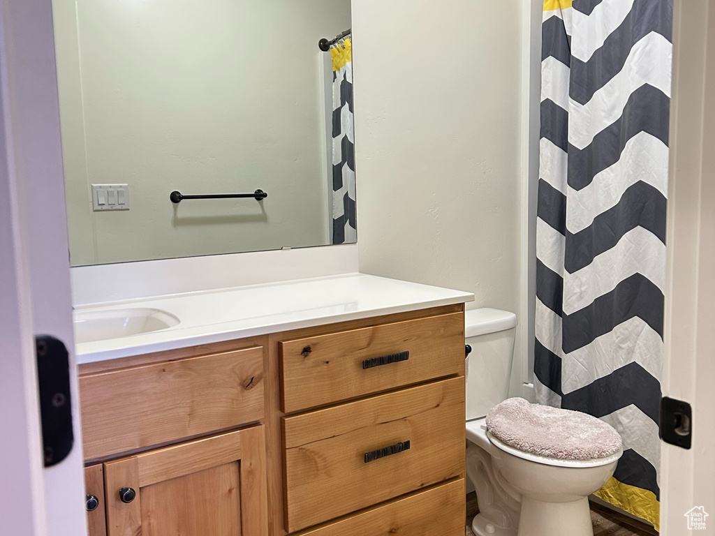 Bathroom with toilet, a textured ceiling, vanity, and wood finished floors
