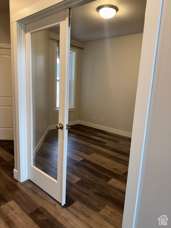 Interior space with dark wood-style floors, baseboards, and a textured ceiling