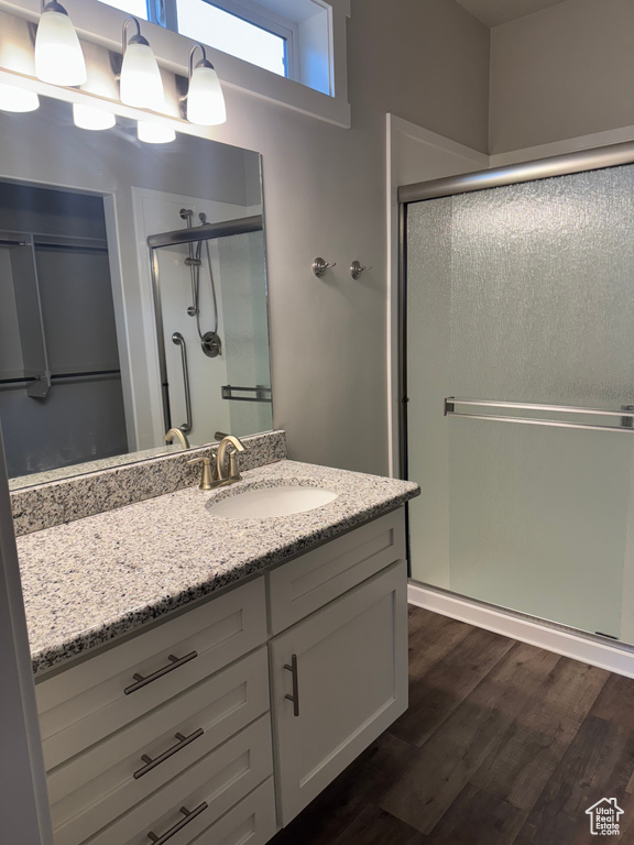 Full bathroom with vanity, wood finished floors, and a shower stall