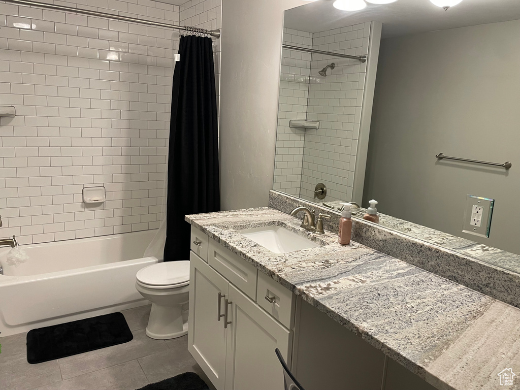 Full bathroom with vanity, toilet, shower / bath combo, and tile patterned floors