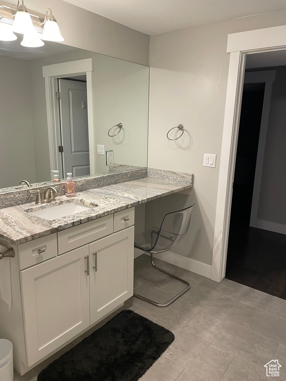 Bathroom with vanity, baseboards, and a chandelier