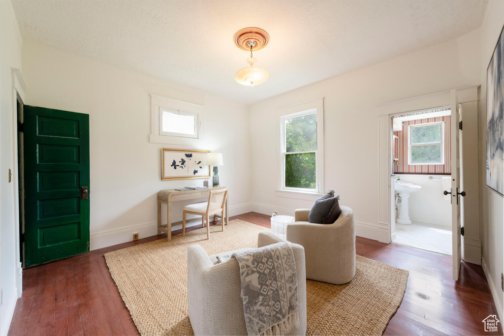 Sitting room with healthy amount of natural light, wood finished floors, and baseboards