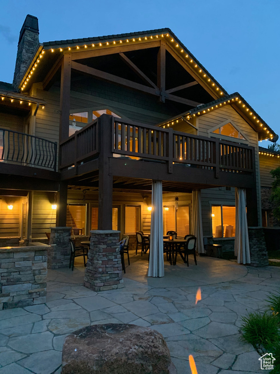 Back of house with outdoor dining space, a chimney, and a patio area