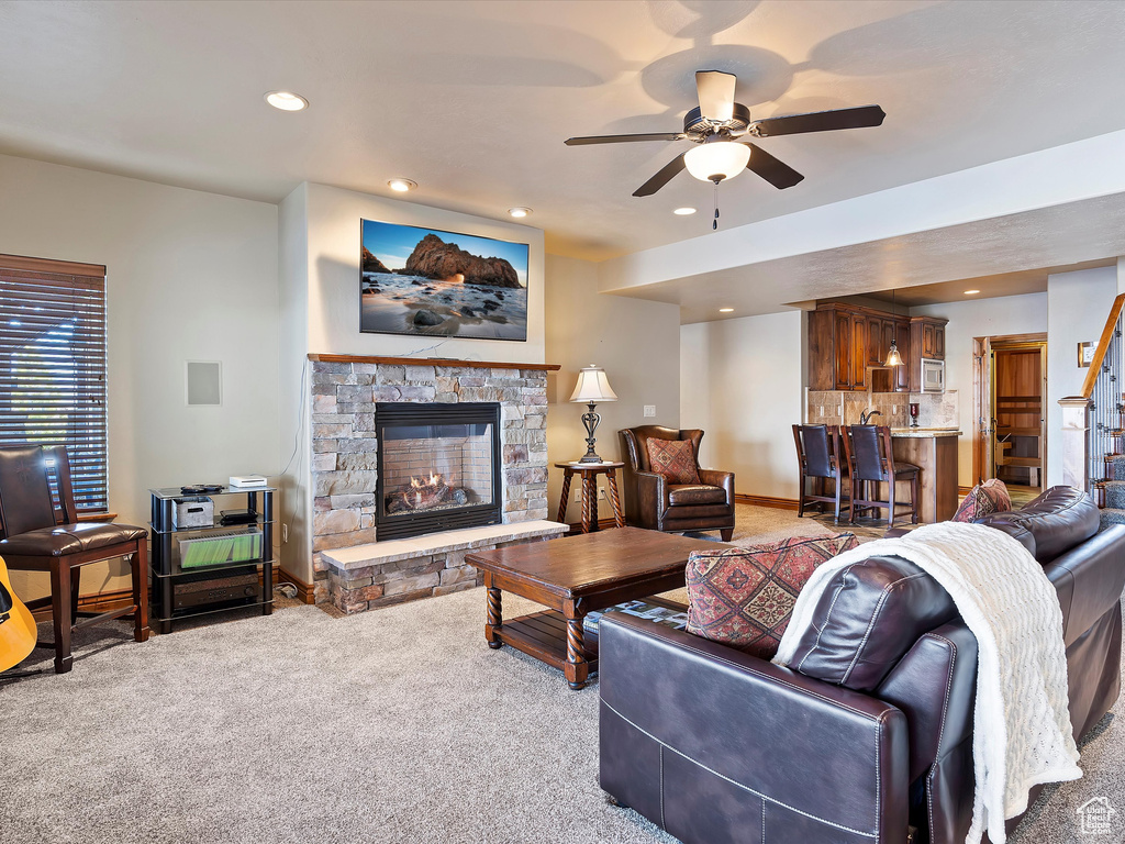 Living area featuring a ceiling fan, recessed lighting, carpet floors, a fireplace, and baseboards