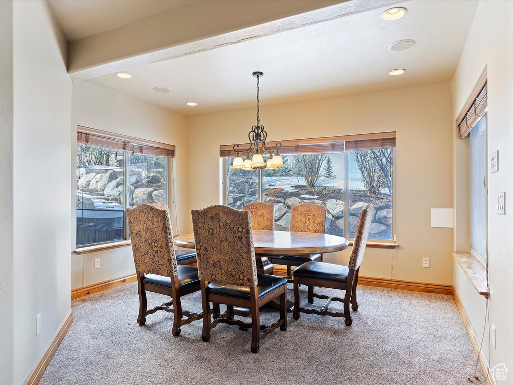 Dining room with plenty of natural light, light colored carpet, and baseboards