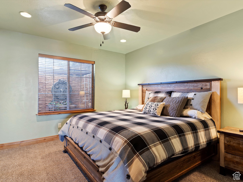 Bedroom with baseboards, a ceiling fan, and carpet flooring