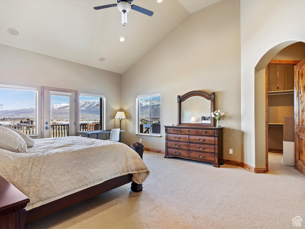 Bedroom featuring arched walkways, carpet flooring, high vaulted ceiling, and access to exterior