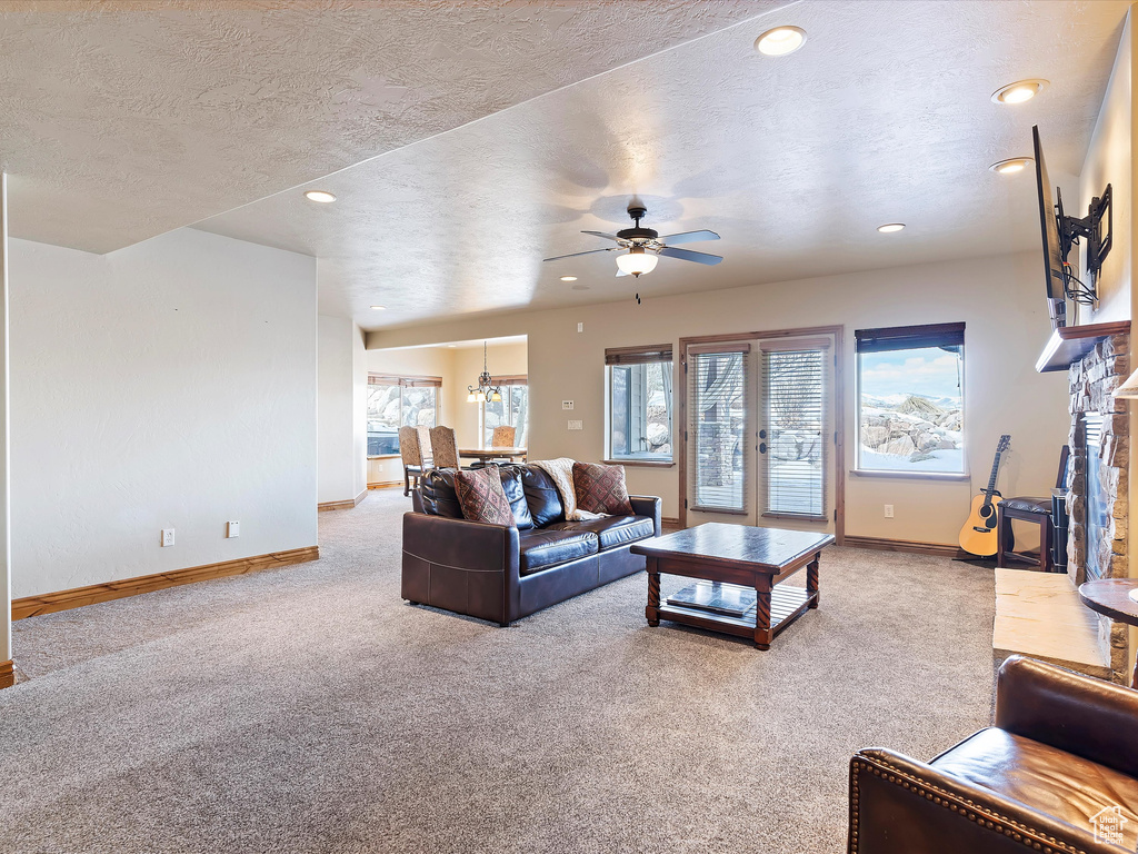 Carpeted living area with recessed lighting, baseboards, a textured ceiling, and a ceiling fan