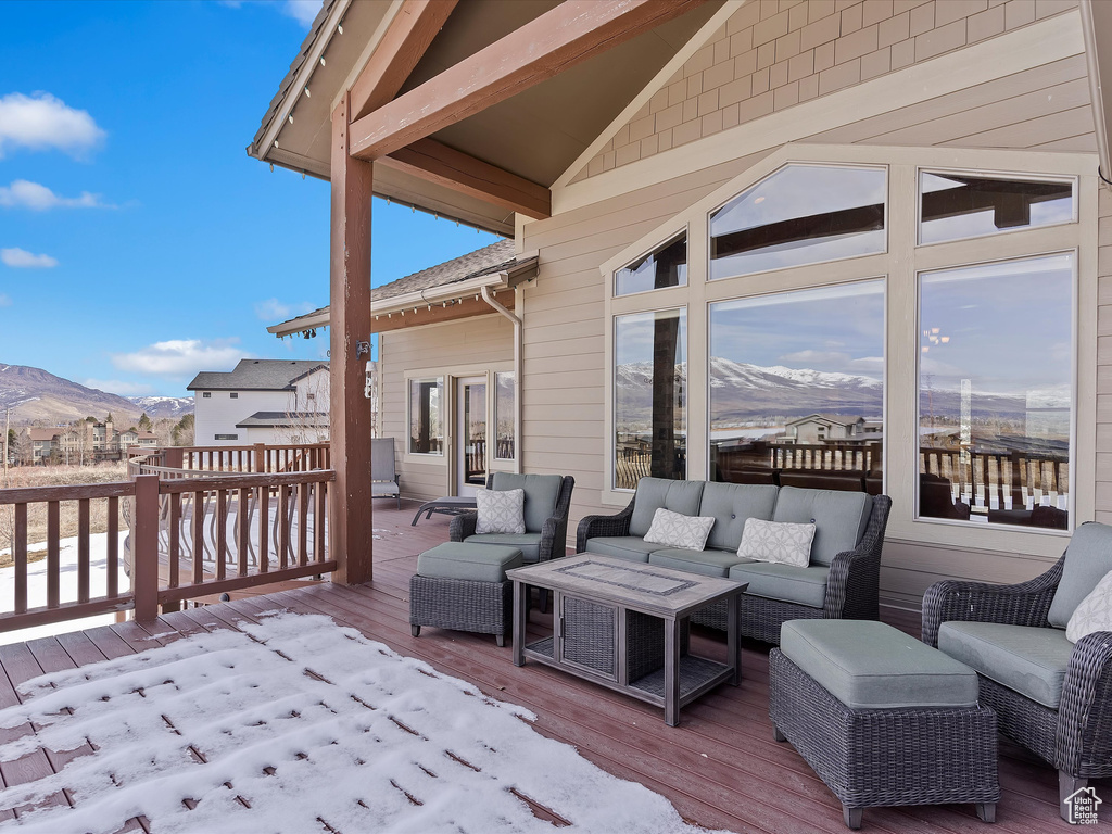 Deck with an outdoor living space and a mountain view