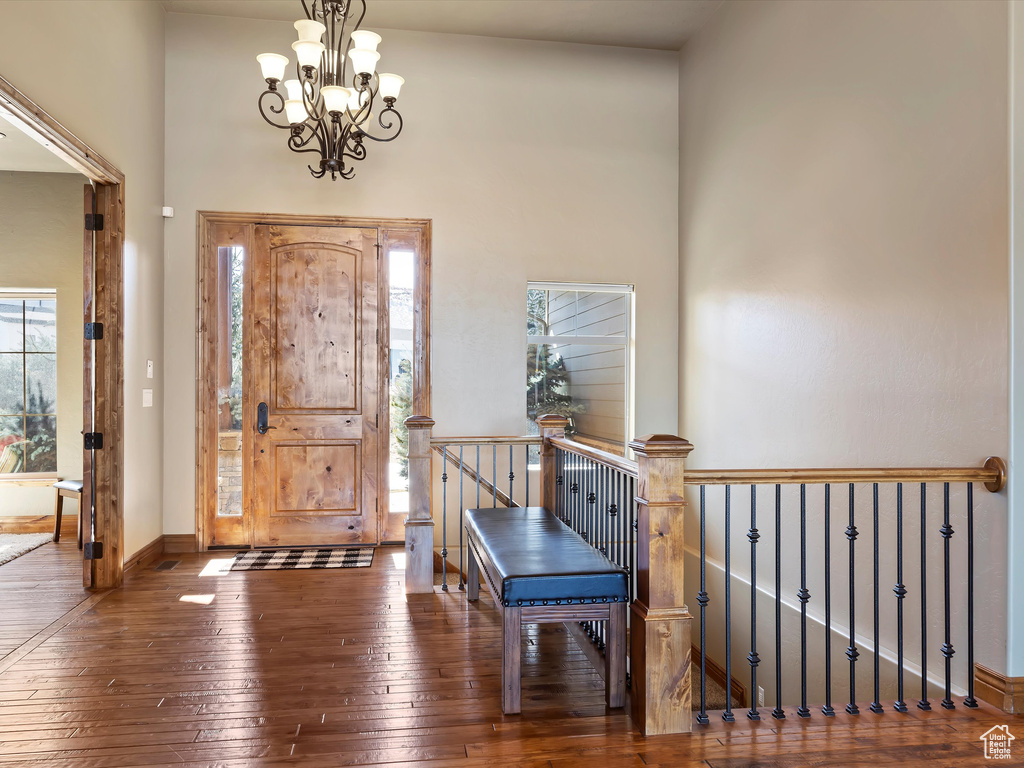 Foyer with an inviting chandelier, baseboards, and wood-type flooring