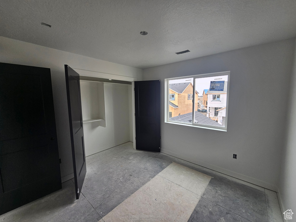 Unfurnished bedroom featuring a closet and a textured ceiling