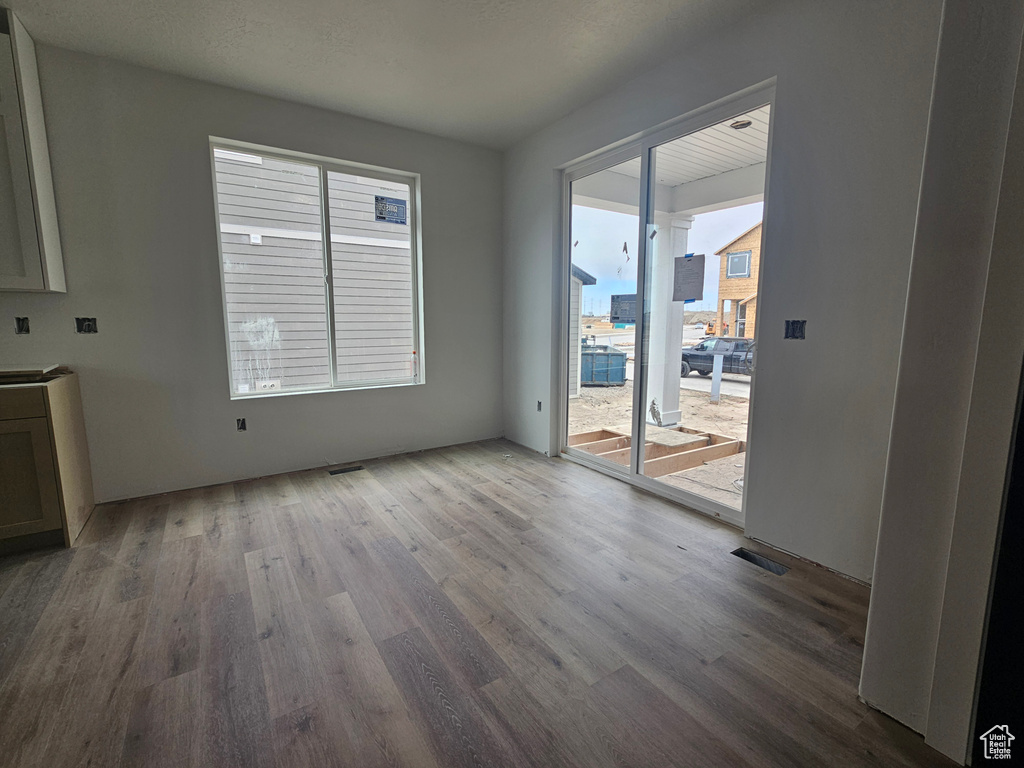 Unfurnished dining area with visible vents and wood finished floors