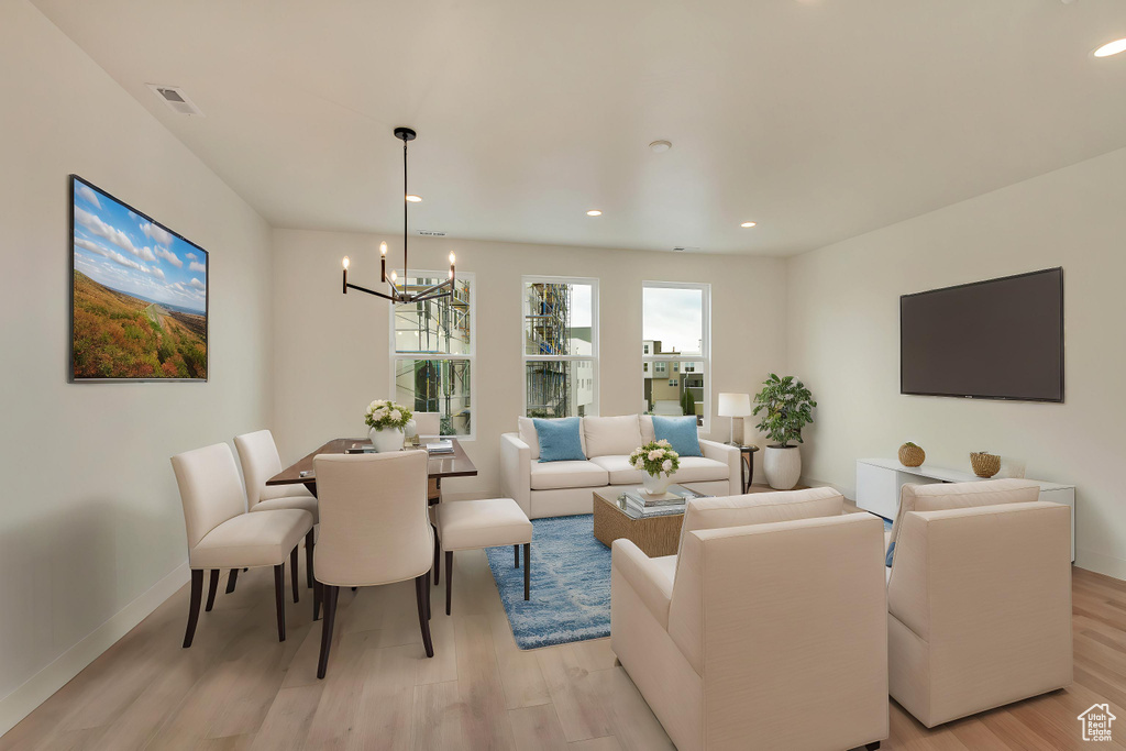Living area featuring a chandelier, light wood-style floors, baseboards, and recessed lighting