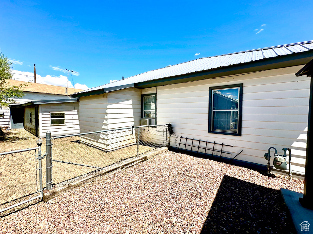 Back of property with fence, metal roof, and a gate