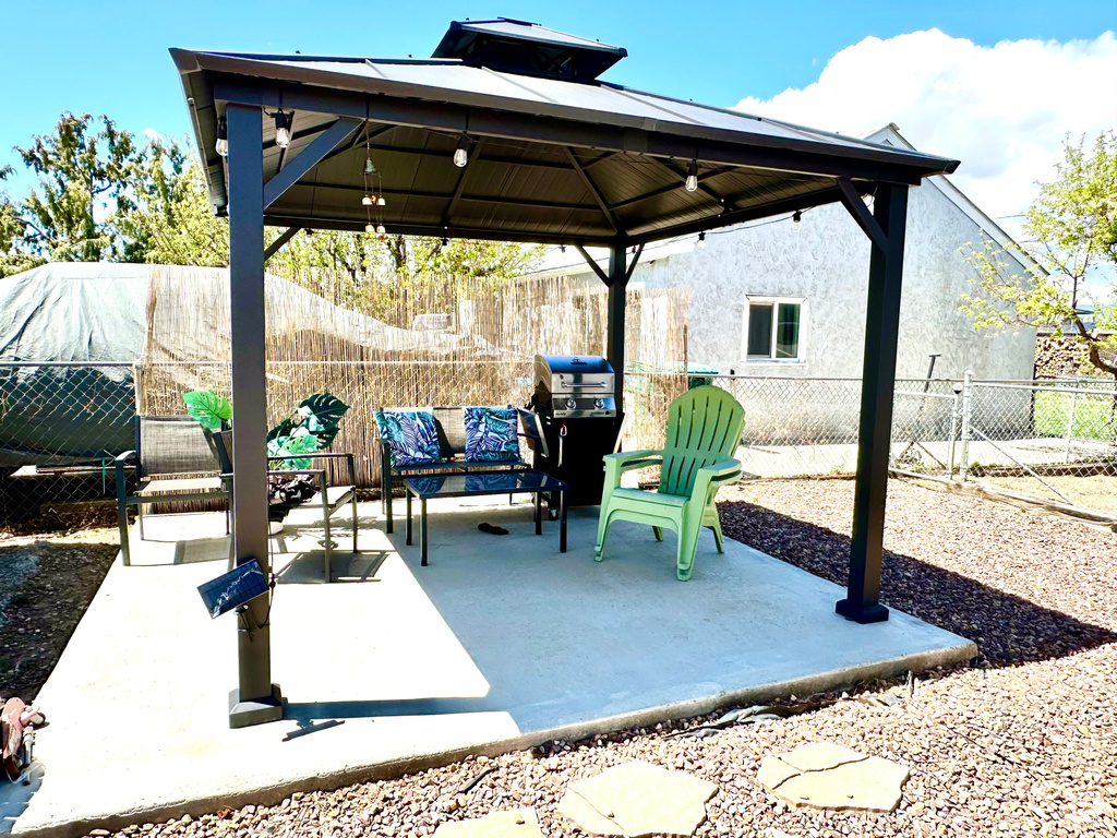 View of patio with a gazebo, an outdoor hangout area, and a fenced backyard
