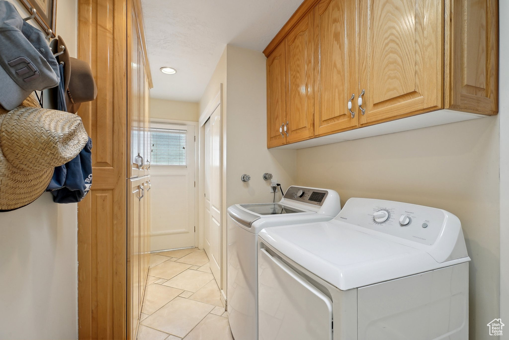 Clothes washing area featuring washer and dryer, cabinet space, recessed lighting, and light tile patterned floors