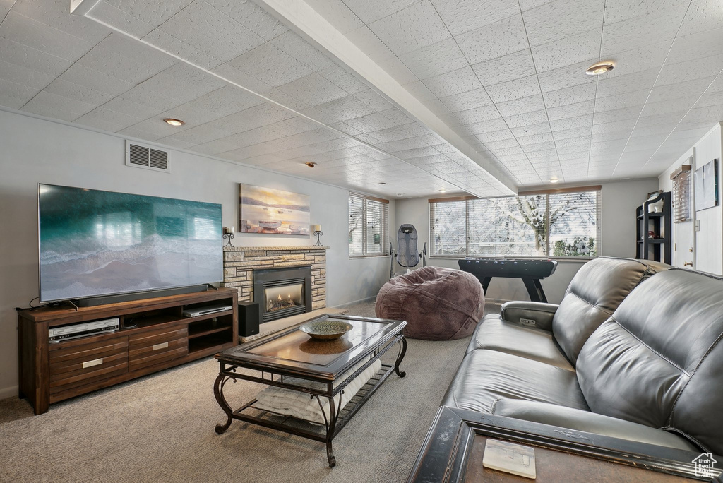 Carpeted living area with a stone fireplace