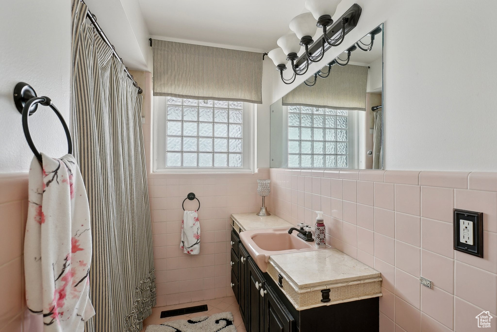 Full bathroom featuring tile walls, vanity, tile patterned flooring, and curtained shower