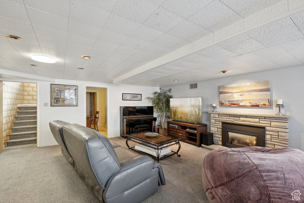 Living area with carpet flooring, stairway, and a fireplace