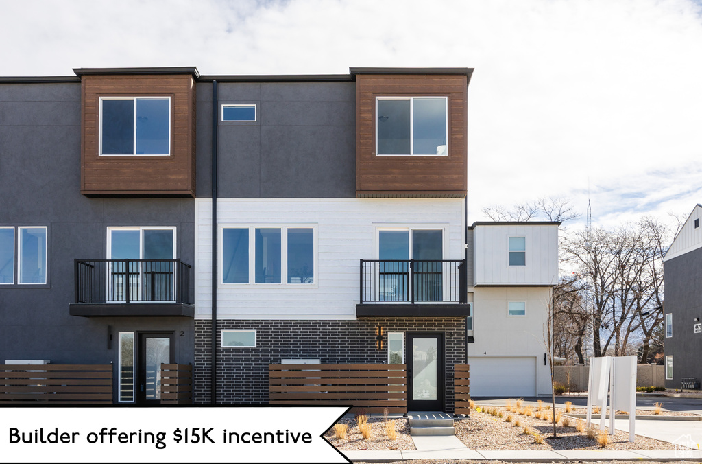 View of front of house with stucco siding and a balcony