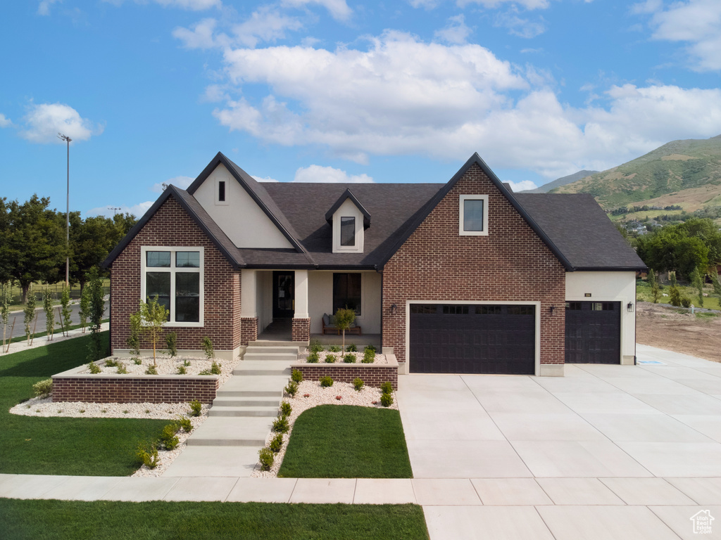 View of front of home featuring brick siding, driveway, a front yard, a garage, and a shingled roof