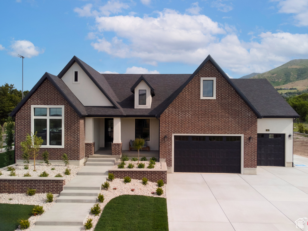 View of front of house featuring concrete driveway, brick siding, covered porch, a shingled roof, and an attached garage