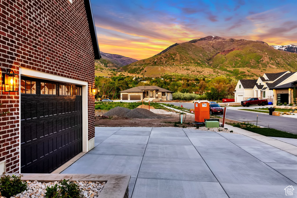 Patio terrace at dusk with a mountain view and a garage