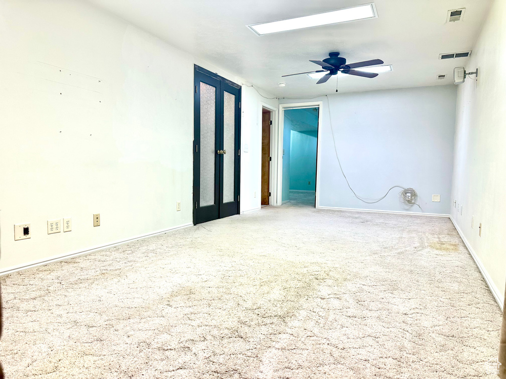 Carpeted spare room featuring a ceiling fan and baseboards