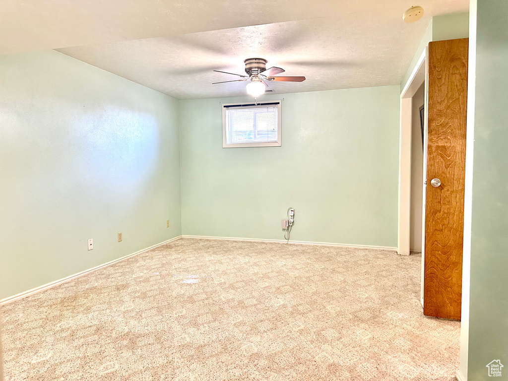 Spare room featuring a textured ceiling, carpet, a smoke detector, ceiling fan, and baseboards