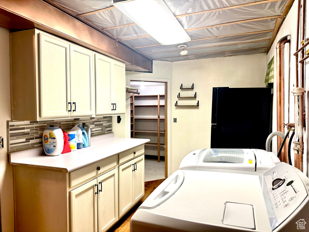 Laundry area featuring independent washer and dryer and cabinet space