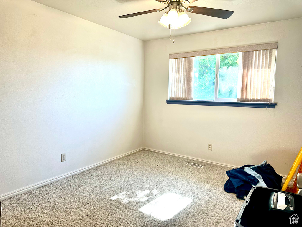 Unfurnished room featuring carpet floors, a ceiling fan, and baseboards