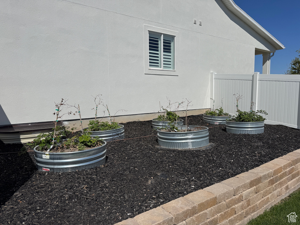 View of yard with a vegetable garden and fence