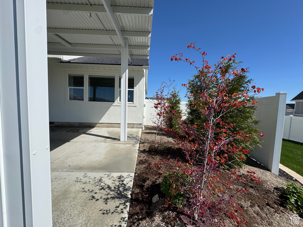 View of home\'s exterior featuring a patio area, roof with shingles, and fence