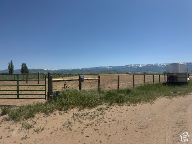 View of yard with a gate, a rural view, a mountain view, and fence