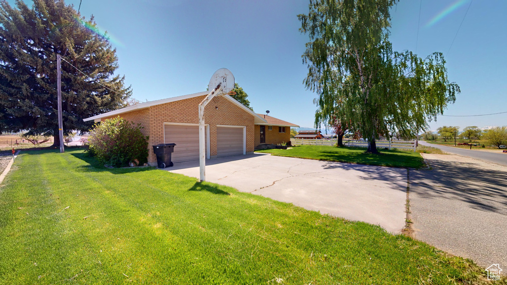 View of home\\\\\\\'s exterior with a garage, brick siding, concrete driveway, and a lawn