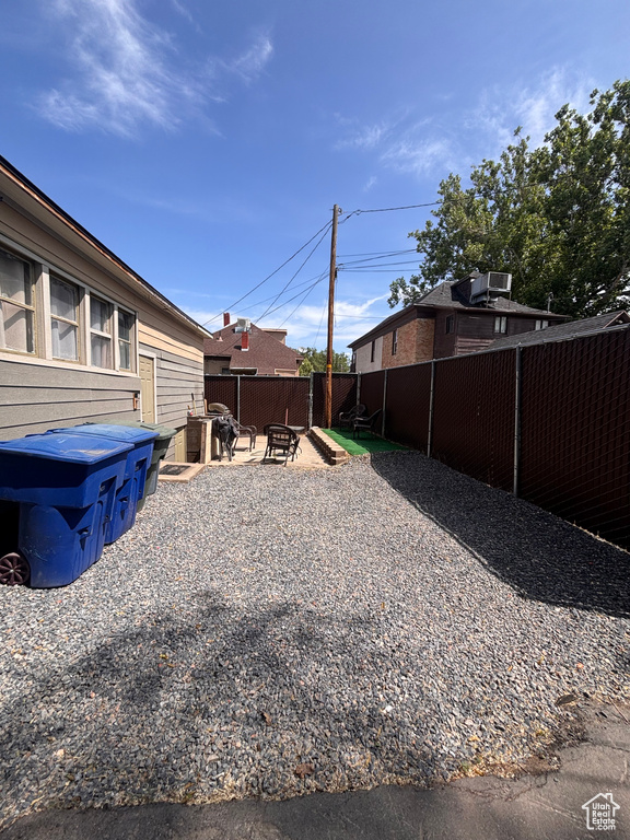 Fenced backyard with an outdoor fire pit, a patio, and central air condition unit