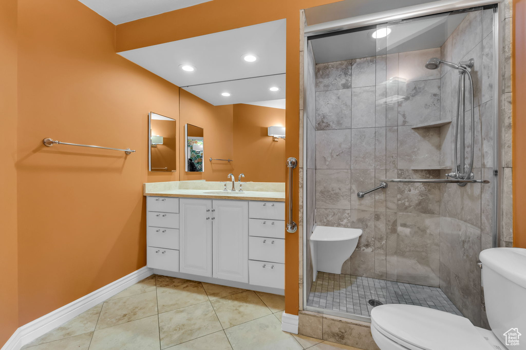 Full bath with toilet, a stall shower, baseboards, vanity, and recessed lighting