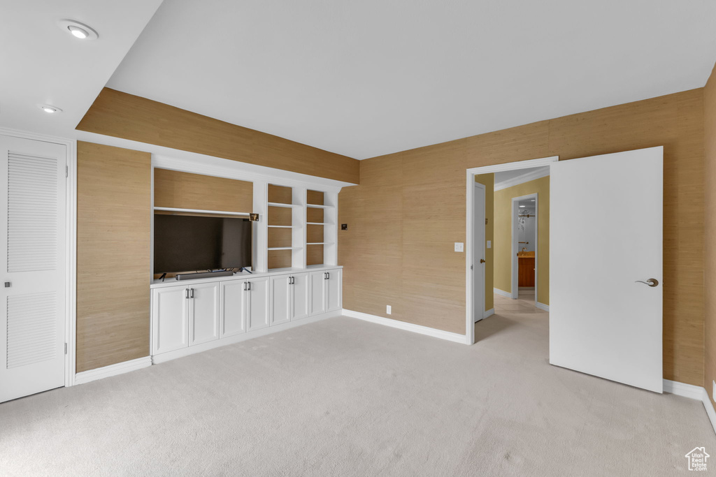 Unfurnished living room featuring baseboards, light colored carpet, and recessed lighting