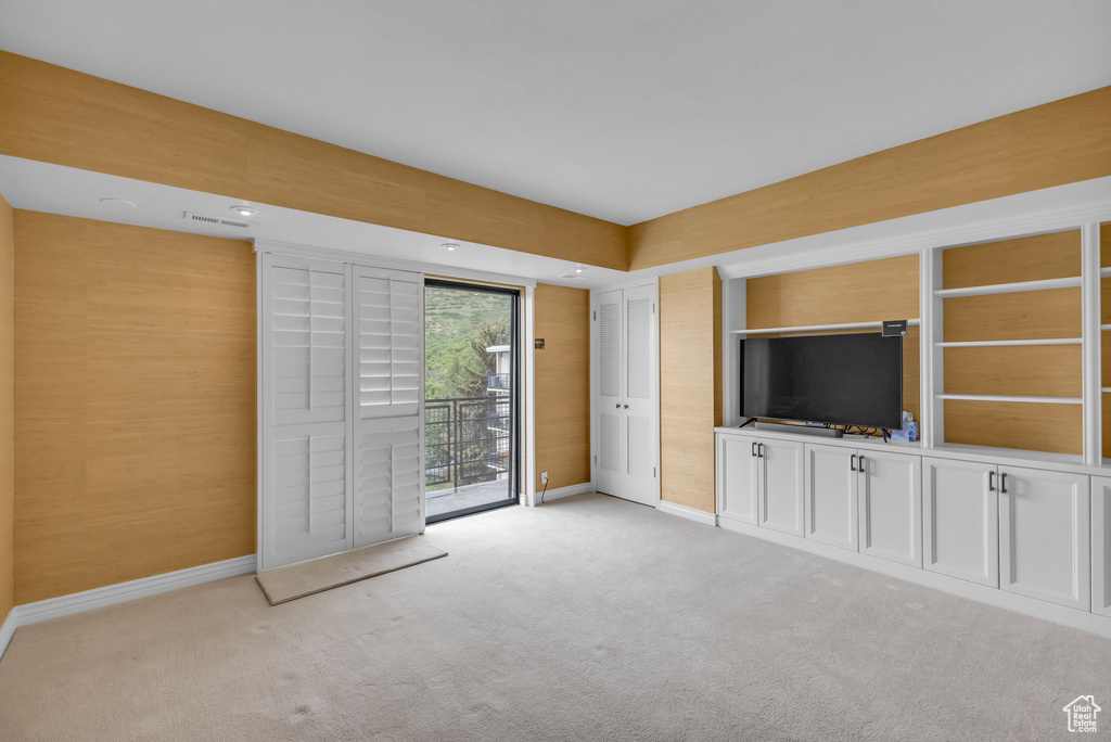 Unfurnished living room featuring baseboards and light colored carpet
