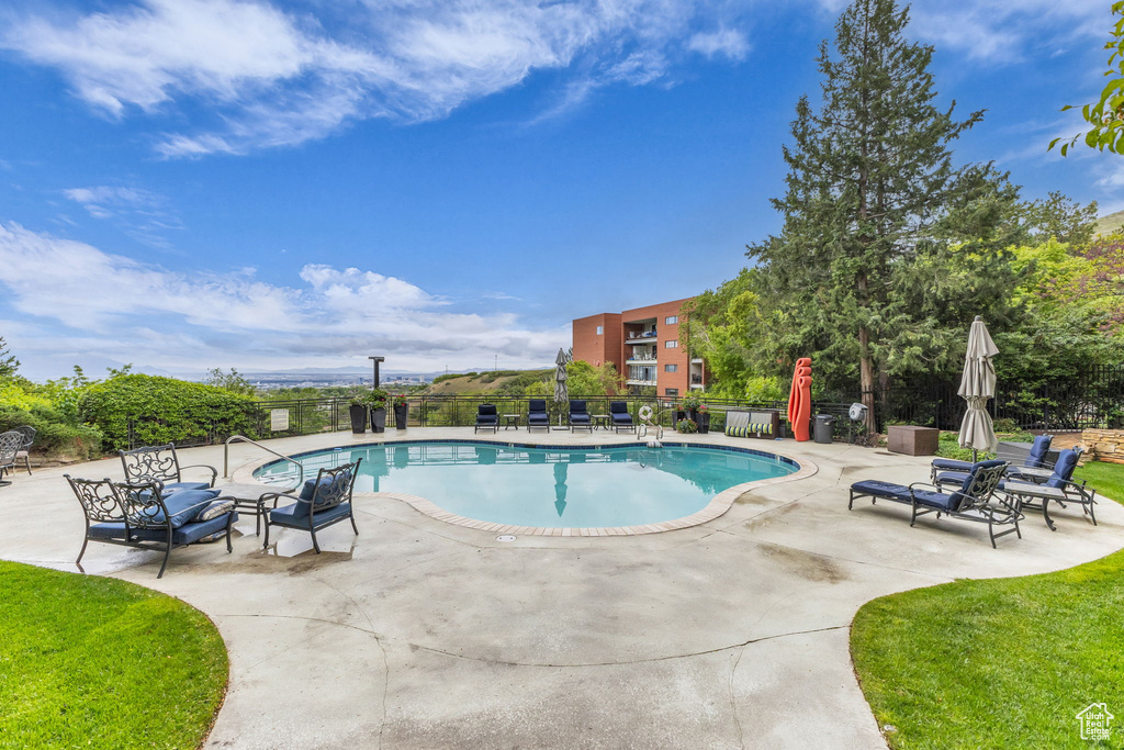 Community pool featuring a patio area and fence