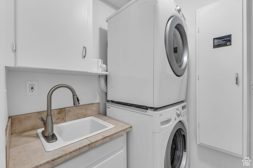 Clothes washing area with stacked washing machine and dryer and cabinet space