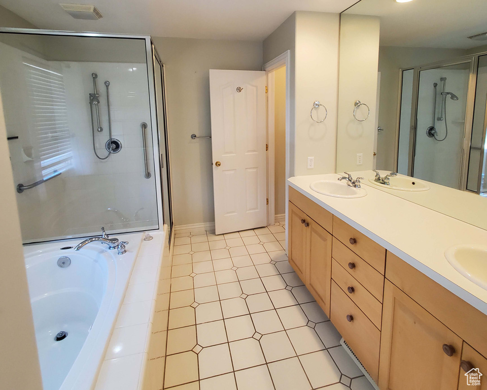 Bathroom with visible vents, a sink, a shower stall, double vanity, and a bath